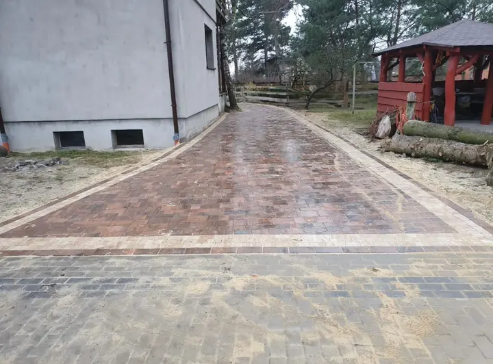 Podjazd z rustykalnej kostki brukowej w odcieniach brązu z jasną opaską